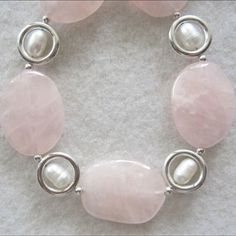 Each Rose Quartz stone in this pretty and delicate necklace is cut like a rose petal and ranges from clear to translucent. The color is a lovely very light pink to soft rose. Designed and handcrafted by Miriam with Sterling Silver rings and white Freshwater Pearls. The shiny silver rings reflect the rosy pink stone color onto the pearls creating an iridescent glow. Rose Quartz is the rosy pink variety of Quartz, which comes in a rainbow of colors as well as crystal clear. The pink to rose red co Elegant Rose Quartz Round Beaded Jewelry, Elegant Rose Quartz Jewelry With Natural Stones, Elegant Round Rose Quartz Bead Jewelry, White Rose Quartz Jewelry For Jewelry Making, Elegant Rose Quartz For Jewelry Making, Rose Quartz Jewelry With Natural Stones For Wedding, Elegant Handmade Rose Jewelry, Delicate Rose Quartz Jewelry For Wedding, Pink Oval Feminine Jewelry