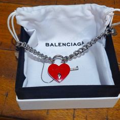 A Red Locket And Silver Chain Balenciaga Necklace In Impeccable Condition Authentic Comes With Box And Bag For Storage Luxury Red Jewelry With Heart Charm, Designer Red Jewelry Gift, Designer Red Jewelry As Gift, Designer Red Jewelry For Gift, Designer Red Bracelet Jewelry, Balenciaga Necklace, Balenciaga Jewelry, Heart Locket Necklace, Heart Locket