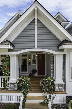 a gray house with white trim and flowers on the front porch is featured in architectural design magazine