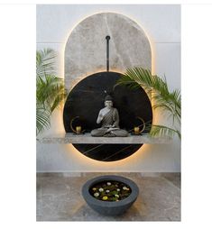 a buddha statue sitting on top of a shelf next to a bowl filled with rocks