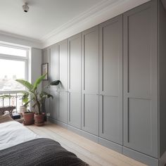 a bedroom with gray cupboards and a plant