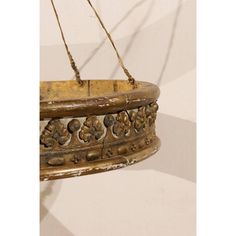 An Italian mid-19th century painted and giltwood bed corona (bed crown). This Italian bed corona has a nicely carved pattern wrapping around its front, reminiscent of a regal crown, over a grey beige painted background. Its backside is flat, in order to be placed flush against a wall. This large-scale bed crown has a nice patina and wear throughout. It hangs with six gold color ropes connected to an o-ring at top. This piece could be hung above a bed to enrich decoration in a bedroom. Bed Crown, Italian Bed, Painted Background, Grey Beige, Grey And Beige, O Ring, Large Size, 19th Century, Gold Color