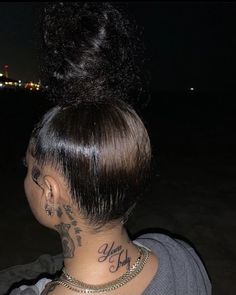 the back of a woman's head with tattoos on her neck and behind her ear