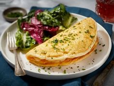 an omelet and salad on a white plate