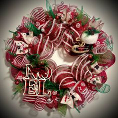 a red and green christmas wreath with the word noel spelled in white letters on it