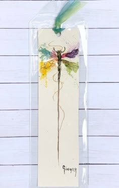 a card with a dragonfly drawn on it's back in clear cellophane