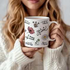 a woman is holding a coffee mug in her hands