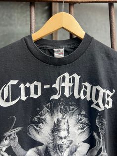 This graphic T-shirt has a design on the front. Cro-Mags Best wishes album cover artwork in black and white Material: 100% Cotton Size: Small Label: AAA Alstyle Apparel Activewear This item is pre-loved Vintage Graphic Print T-shirt For Alternative Fashion, Vintage Text Print T-shirt For Music Festivals, Alternative Logo Print T-shirt For Concerts, Vintage Black T-shirt With Graphic Design, Vintage Text Print T-shirt For Concert, Vintage Concert T-shirt With Text Print, Alternative Concert T-shirt With Logo Print, Alternative Style Concert T-shirt With Logo Print, Black Band Logo T-shirt For Alternative Fashion