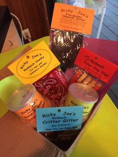 a box filled with lots of different types of food and drink items on top of a table