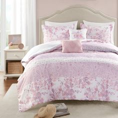 a bed with pink and white comforters in a bedroom