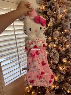 a hello kitty christmas stocking hanging from a tree