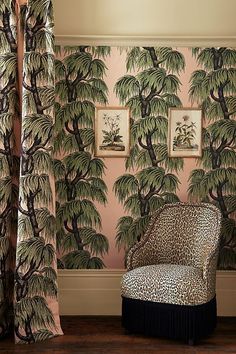 a leopard print chair in front of a pink wall with palm trees on the walls