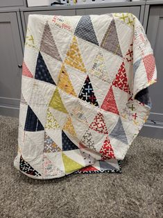 a quilt is laying on the floor in a kitchen