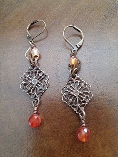 This earring design has a vintage, yet traditional look. Antique Brass lever backs give you the security to wear these and not of lose an earring. The small filigree on top cradles the light natural faceted Carnelian stone.  The diamond shaped Vintaj Brass filigree has been polished to reveal the golden color of natural Brass.  A faceted and natural dark orange Carnelian is layered on top. These Aged Brass Filigree connectors are Lead and Nickel free, Made in the USA. 20.00 Gift Box Included Tha Vintage Teardrop Clip-on Earrings As Gift, Vintage Handmade Brass Clip-on Earrings, Handmade Vintage Brass Clip-on Earrings, Handmade Adjustable Vintage Clip-on Earrings, Vintage Brown Dangle Jewelry, Handmade Vintage Drop Chandelier Earrings, Handmade Vintage Chandelier Drop Earrings, Bohemian Drop Earrings For Vintage Collection, Handmade Metal Earrings For Vintage Collection