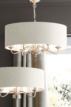 a chandelier hanging from the ceiling in a living room with two lamps on it