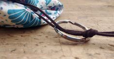 a close up of a pair of scissors on a wooden table next to a bag