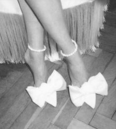 black and white photograph of woman's legs with bows