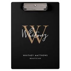 a clipboard with the word w written in white ink on black paper and gold foil