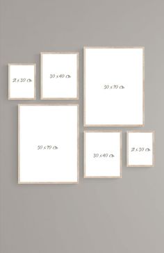 four white frames with numbers on them against a gray wall