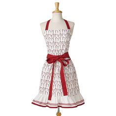 a white and red apron dress on a mannequin stand with a red ribbon around the waist