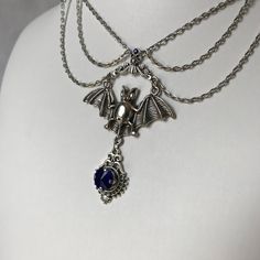 This gothic vampire inspired necklace is made with an antiqued silver plated bat. filigrees and findings, accented with sparkling glass crystals in DARK SAPPHIRE BLUE. Decorated portion is 6" wide and centerpiece is 2 7/8" tall in the center.Necklace is adjustable 15-18" with a lobster clasp and chain extender in the back. If you would like a different length or stone color, please send us a message. Gothic Costume Choker Necklace, Blue Gothic Metal Necklace, Gothic Blue Metal Jewelry, Gothic Costume Jewelry Choker, Gothic Sterling Silver Choker, Gothic Sterling Silver Choker Jewelry, Gothic Sterling Silver Choker Necklace, Blue Gothic Metal Jewelry, Halloween Gothic Pendant Jewelry