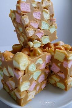 three pieces of cake sitting on top of a white plate with pink and green toppings