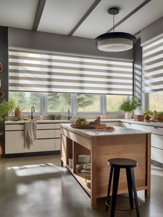 a modern kitchen with an island in the middle and vertical blinds on the windows behind it