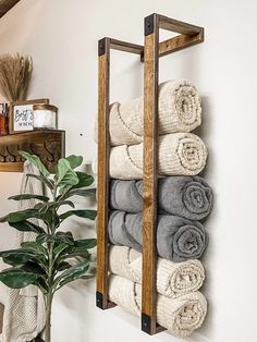 a towel rack with towels hanging on it next to a potted plant in a bathroom