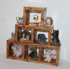 a wooden shelf filled with small figurines on top of each other