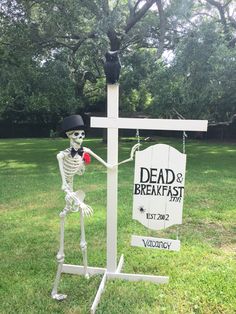 a skeleton with a top hat and bow tie holding an apple in front of a sign that says dead & breakfast