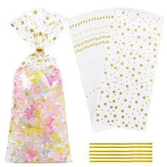 gold foil stars and white paper bags with straws on the side, one bag is filled