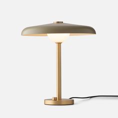 a lamp that is sitting on top of a white surface with a cord attached to it