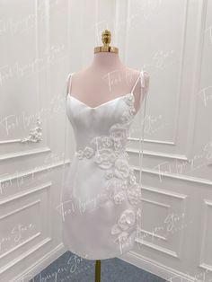 a white wedding dress on display in a room