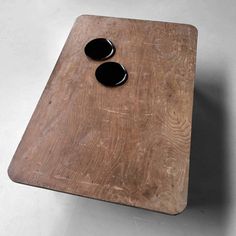 a wooden table with two black stones on it