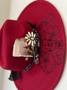 Be the life of the rodeo in this gorgeous boho red hat featuring a bull, poppies, and playful longhorns. Add this accessory to your wardrobe for a unique western touch. Western Cowgirl Hats, Red Western Hat For Fall, Adjustable Red Hat Bands For Spring, Red Hats For Rodeo Spring Season, Red Hat For Rodeo Spring Season, Red Hats For Rodeo In Spring, Red Spring Rodeo Hat, Handmade Southwestern Style Hat Bands, Red Western Hat Bands For Kentucky Derby