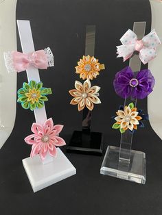 three different types of hair bows on display in front of a black background and white backdrop