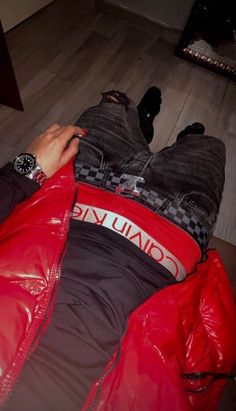 a person laying on the floor in a red jacket