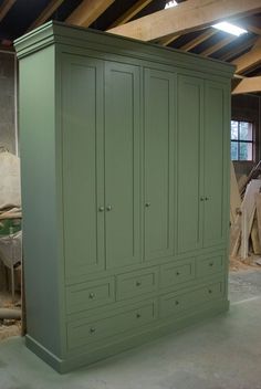 a green armoire sitting in the middle of a room