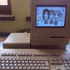 an old computer sitting on top of a desk next to a keyboard and mouse with anime characters on the screen