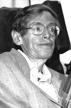 black and white photograph of a man in glasses holding a book while sitting on a chair