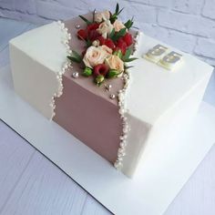 a square cake with flowers and pearls on top