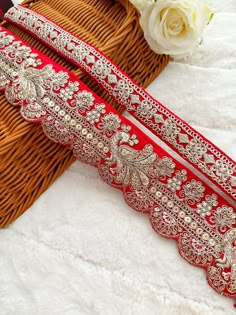 two red and gold garters sitting on top of a bed next to a basket