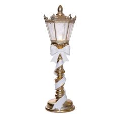 a gold lamp with a white ribbon on it's end and a light bulb attached to the top