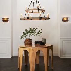 a chandelier hanging from the ceiling over a table with some candles on it