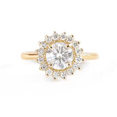 a yellow gold engagement ring with an oval diamond center surrounded by small round brilliant cut diamonds