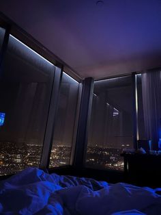 a bedroom with a view of the city at night