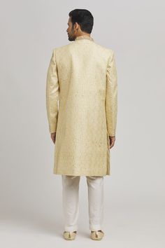 Ivory and golden sherwani with floral frame embroidery. Paired with an inner kurta and churidar. - Aza Fashions Gold Jamawar Sets For Reception, Gold Sherwani With Intricate Embroidery In Raw Silk, Traditional Gold Raw Silk Wear With Naqshi, Gold Traditional Wear With Naqshi Drape, Traditional Gold Unstitched Suit With Naqshi Detailing, Traditional Gold Unstitched Suit With Naqshi, Gold Straight Kurta For Reception, Festive Gold Sherwani With Naqshi Detailing, Festive Gold Sherwani With Naqshi