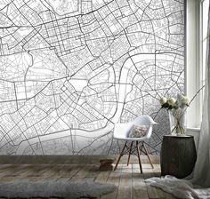 a white chair sitting in front of a window next to a wall with a map on it