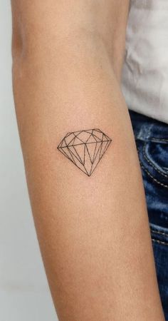 a woman's arm with a small diamond tattoo on the left side of her arm