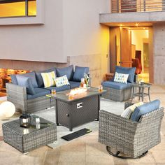 an outdoor living room with wicker furniture and blue cushions on the outside patio area